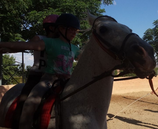 dos ninas a los lomos de un caballo blanco
